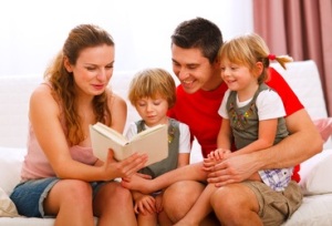 Mother and father reading to twins daughters